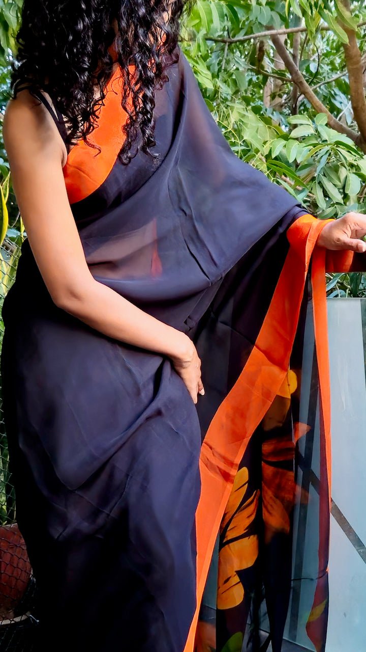 Deep black organza saree with fiery orange hand painted and printed floral art