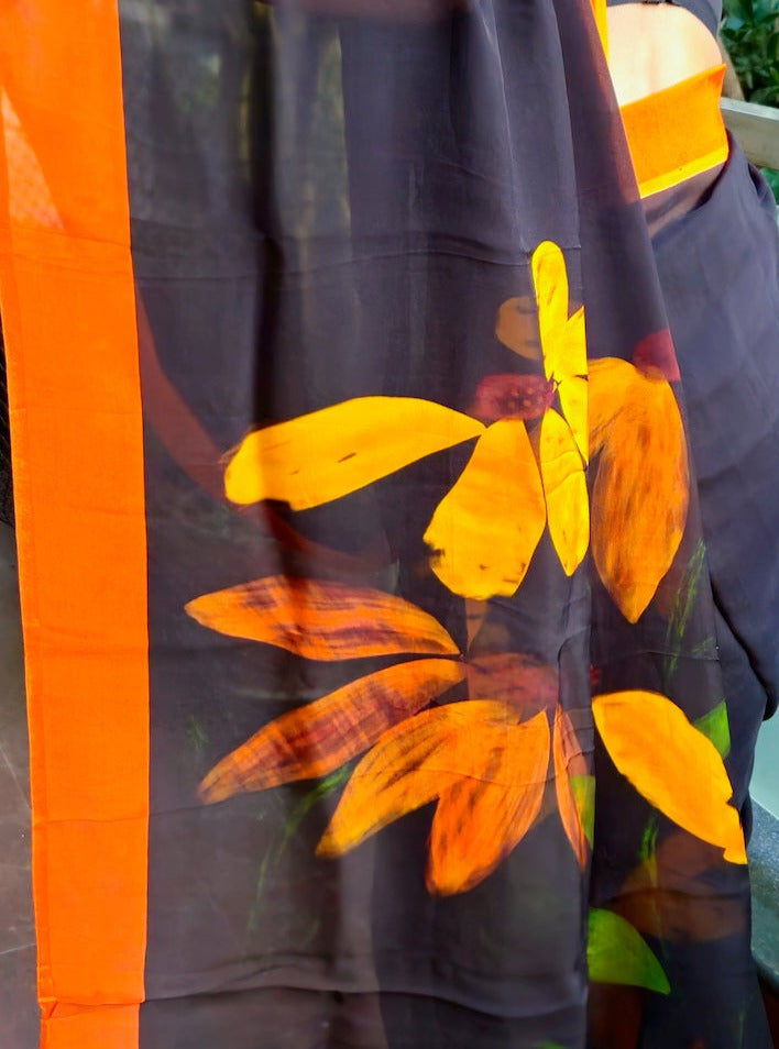 Deep black organza saree with fiery orange hand painted and printed floral art