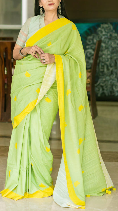 Lively green linen saree with bright yellow border, motifs and tassels.