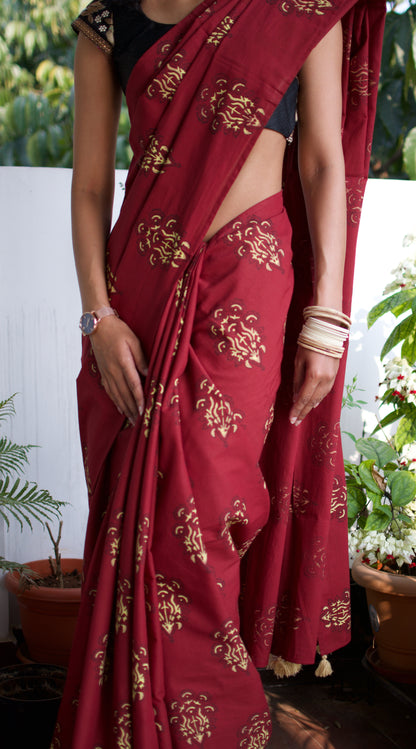 Cotton handcrafted, naturally dyed saree in maroon colour with handblock print of a floral motif all over the saree.