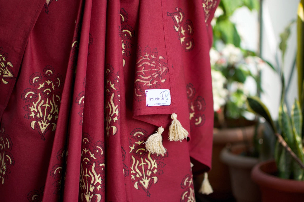 Cotton handcrafted, naturally dyed saree in maroon colour with handblock print of a floral motif all over the saree.