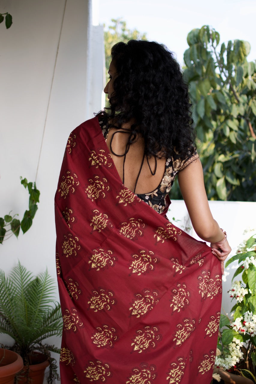 Cotton handcrafted, naturally dyed saree in maroon colour with handblock print of a floral motif all over the saree.