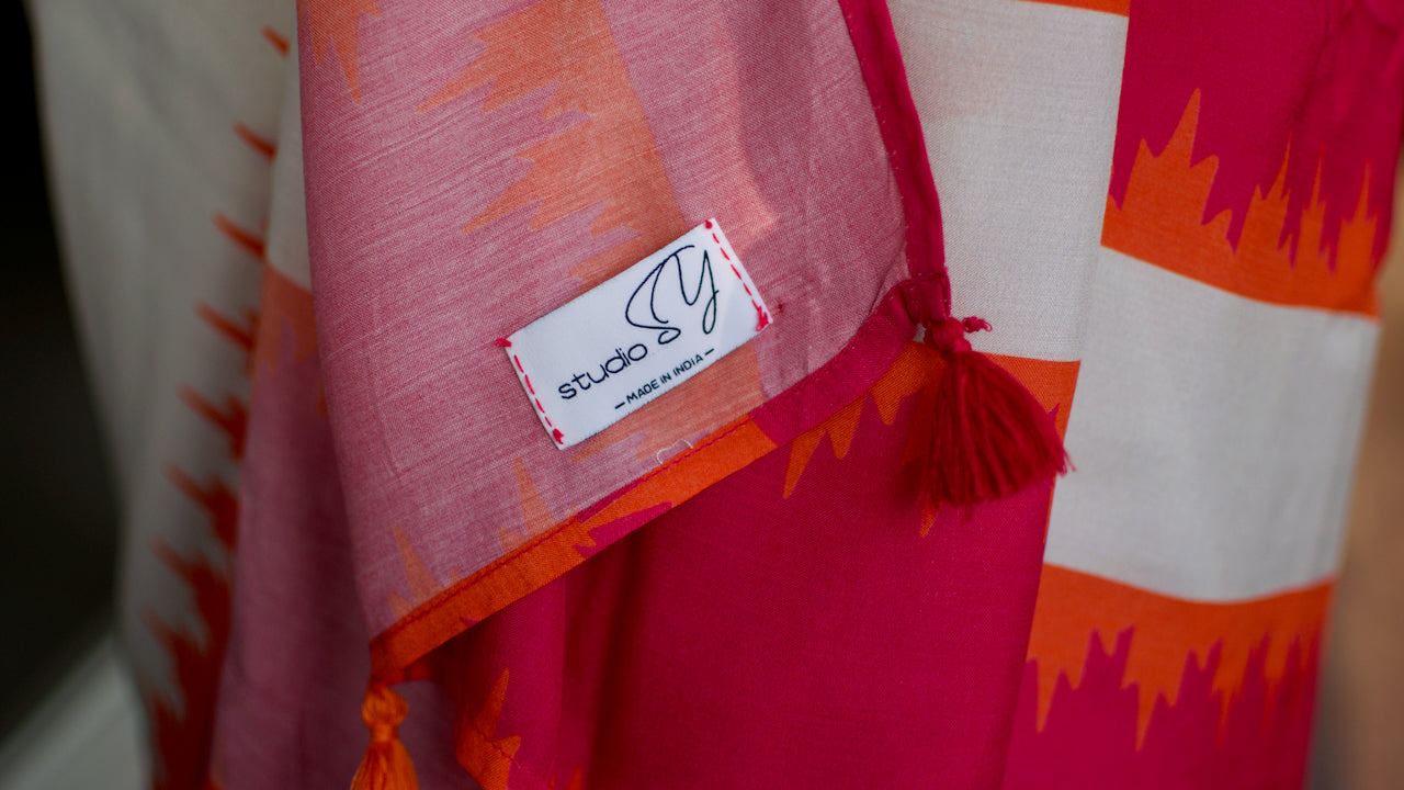 Muslin handcrafted, naturally dyed saree in a shade of white with popping colour combination of orange and pink.
