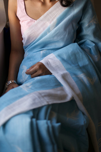 Linen Cotton handcrafted, naturally dyed saree in blue colour with white border and feather motifs.