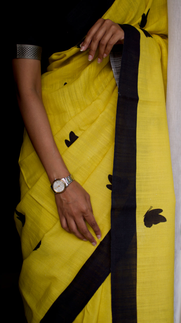 Linen Cotton handcrafted, naturally dyed saree in yellow colour with black border and butterfly motifs.