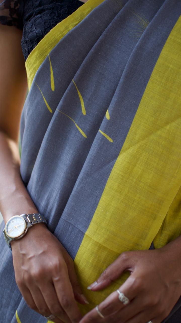 Linen Cotton handcrafted, naturally dyed saree in grey colour with yellow border and dandelion motifs.