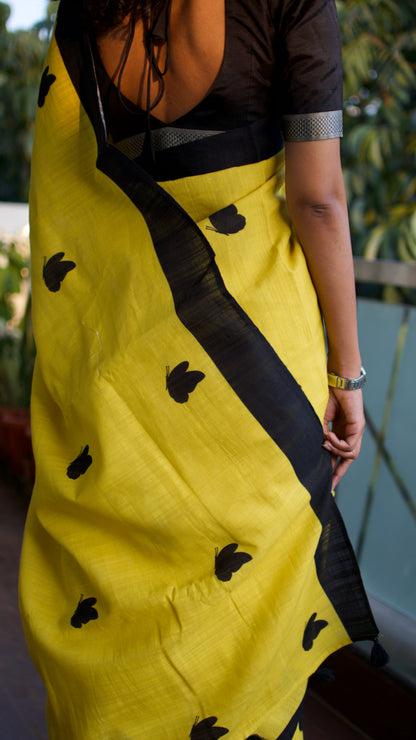 Linen Cotton handcrafted, naturally dyed saree in yellow colour with black border and butterfly motifs.